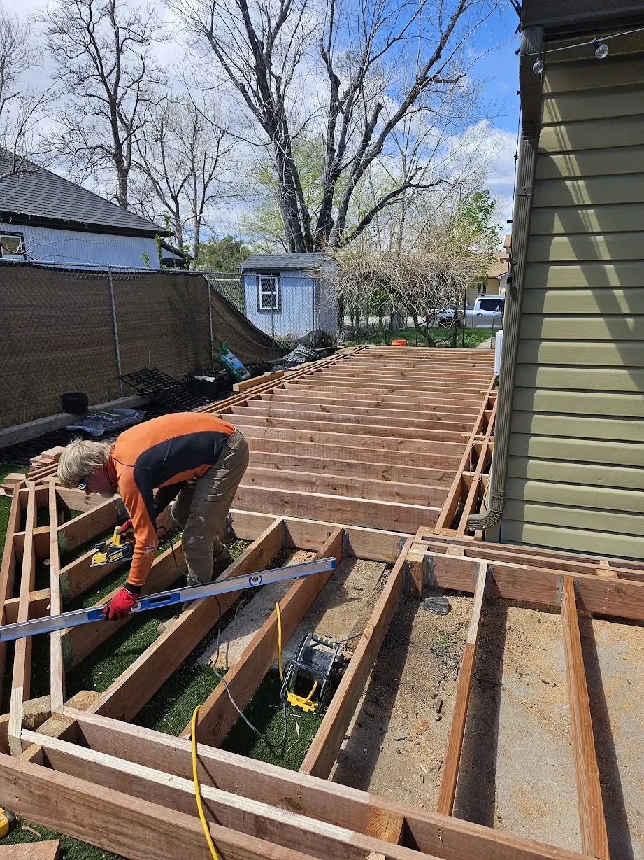 Deck joists and corner framing being aligned during construction of a Littleton composite deck