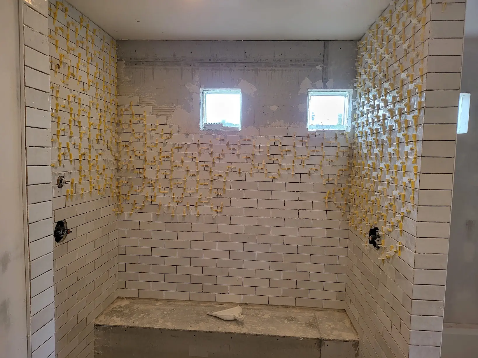White wall tile installation in the relocated shower during a Denver bathroom remodel