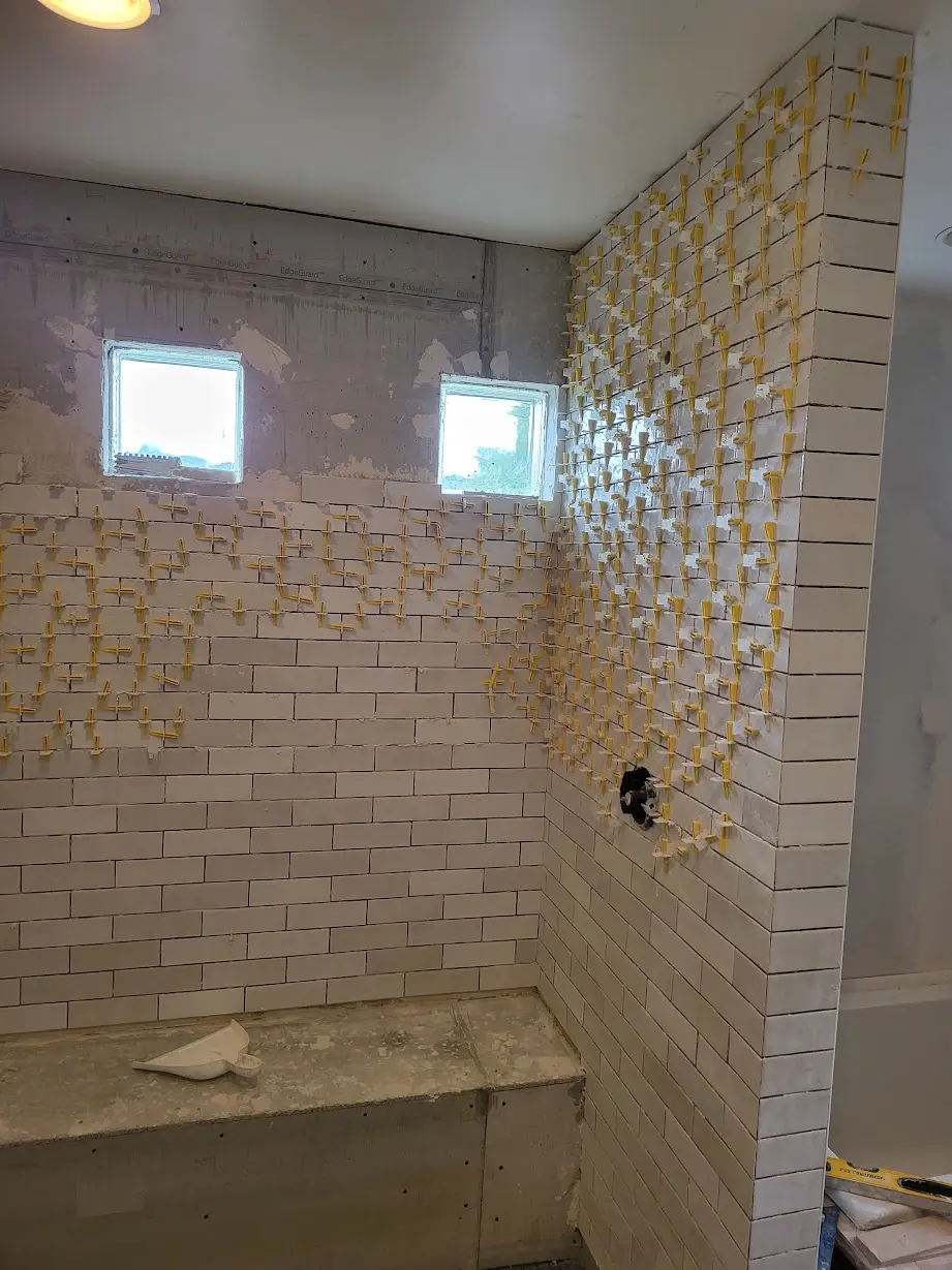 Detailed view of wall tile installation around the new shower enclosure