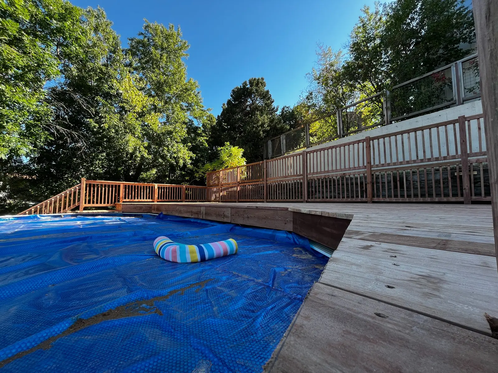 Completed pressure-treated wood deck surrounding an above-ground pool in Lakewood, Colorado