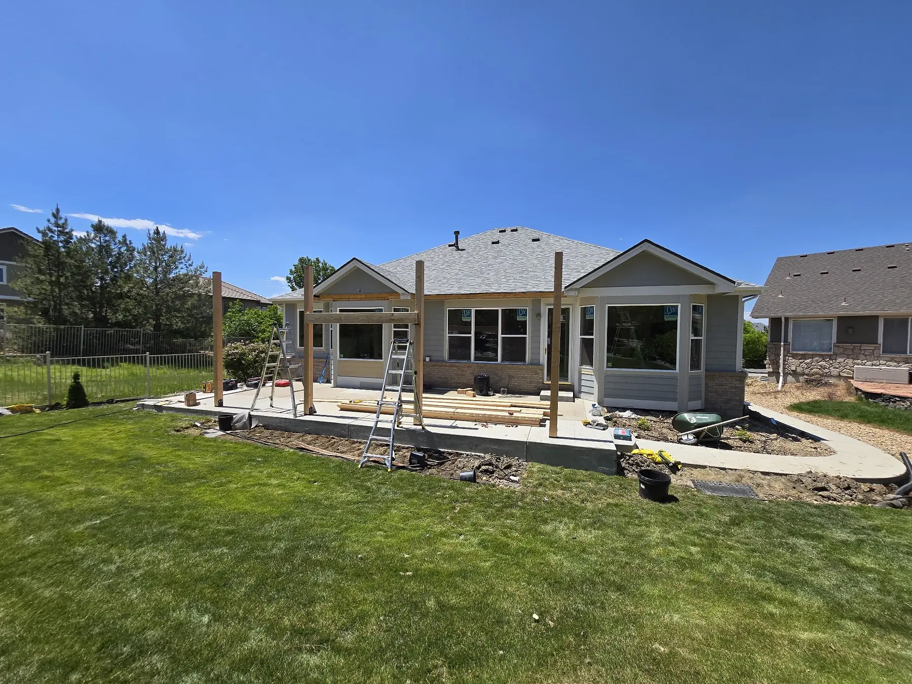 Wood posts and beams being installed for a new covered patio at an Aurora home