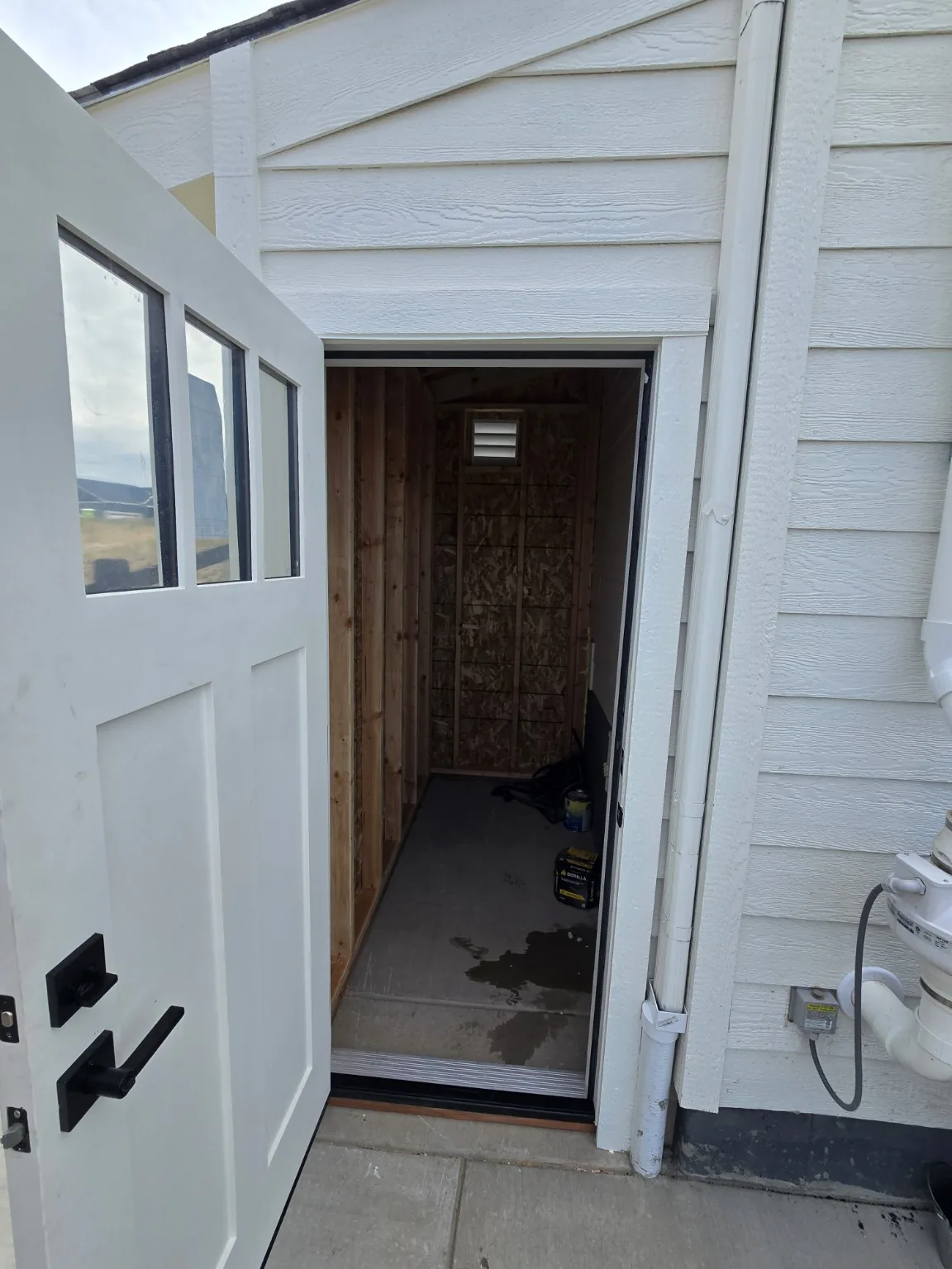Open entry door showing the protected landing inside the Castle Rock basement entrance enclosure