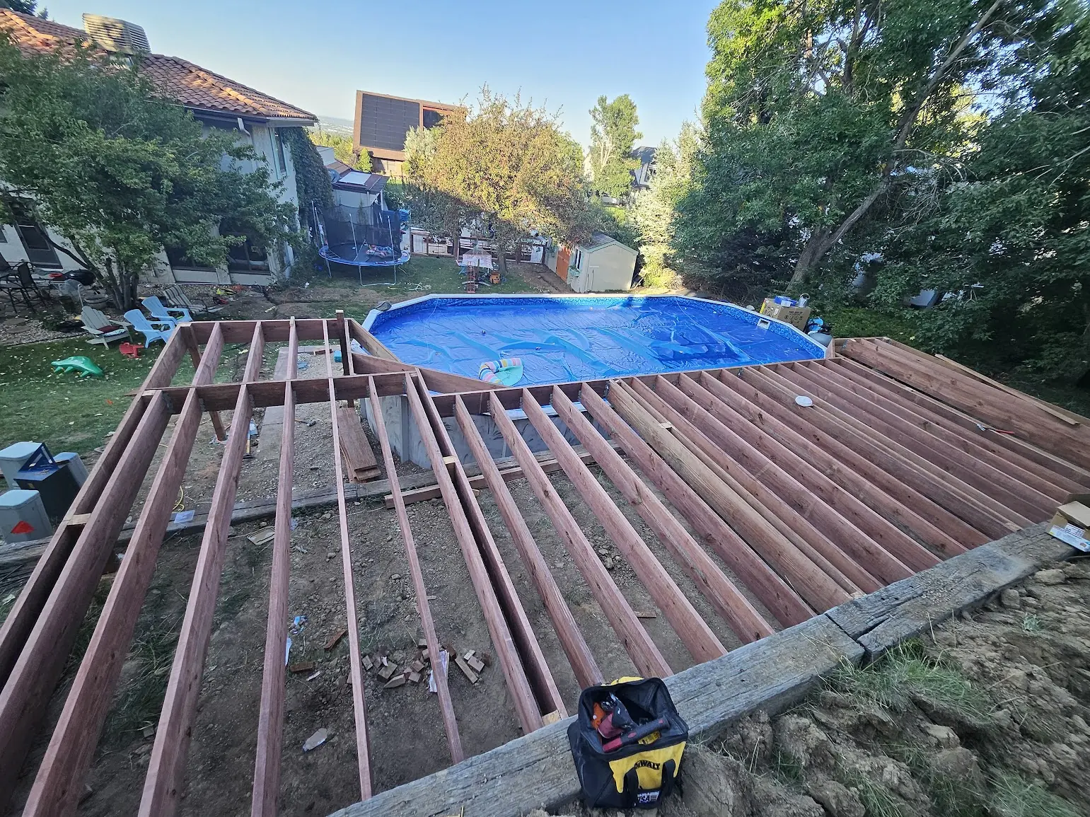 Wide view of pressure-treated wood framing being built around an above-ground pool in Lakewood