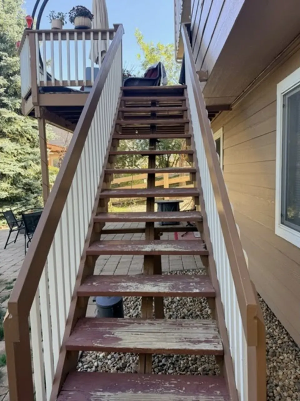 Worn deck stair treads with peeling paint before repair