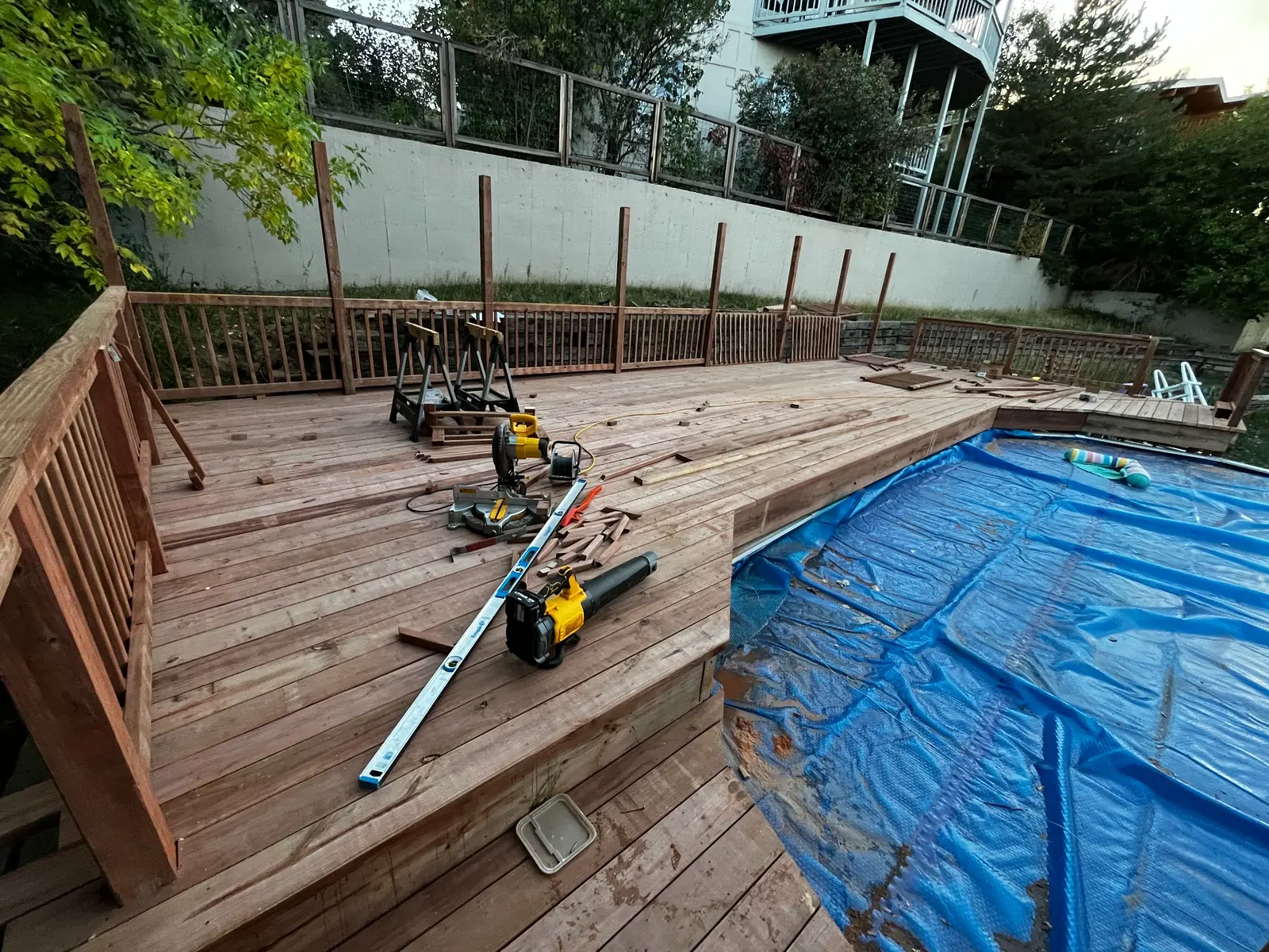 Pressure-treated wood railings being installed on a pool deck under construction in Lakewood