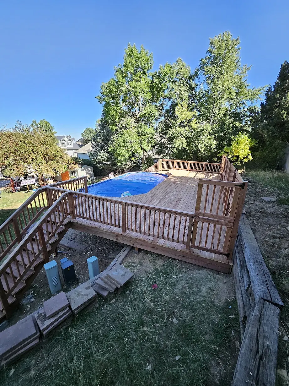 Completed pressure-treated wood deck with railings surrounding an above-ground pool in Lakewood