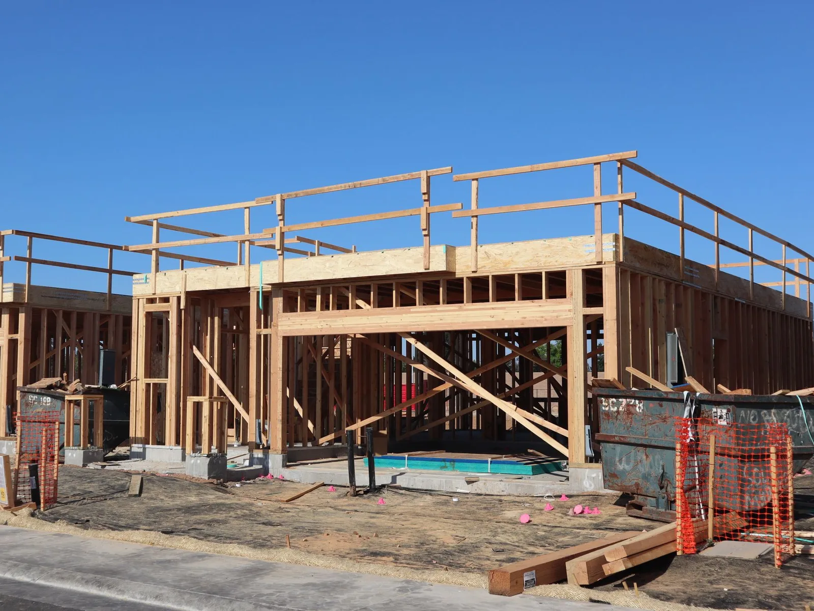 Residential framing and construction work progressing on site.