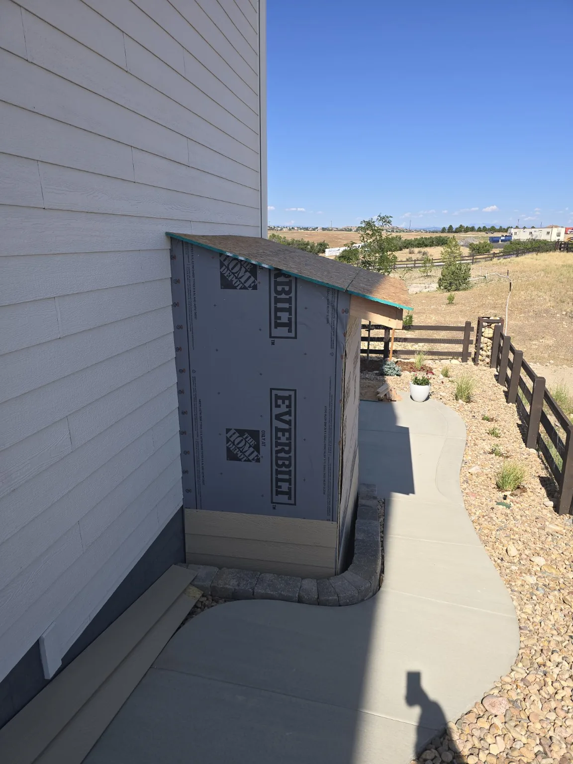 Basement entrance enclosure dried in with house wrap and a shingled shed roof in Castle Rock
