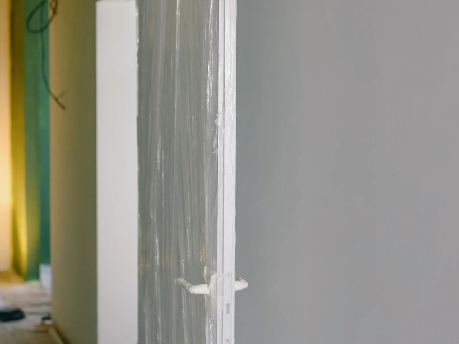 Protected doors and surfaces wrapped in plastic before residential construction begins.