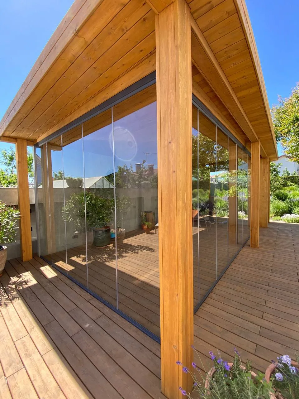 Wood-framed patio enclosure with floor-to-ceiling sliding glass panels