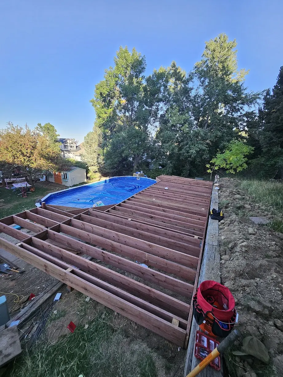 Pressure-treated deck joists and perimeter framing during construction of a Lakewood pool deck