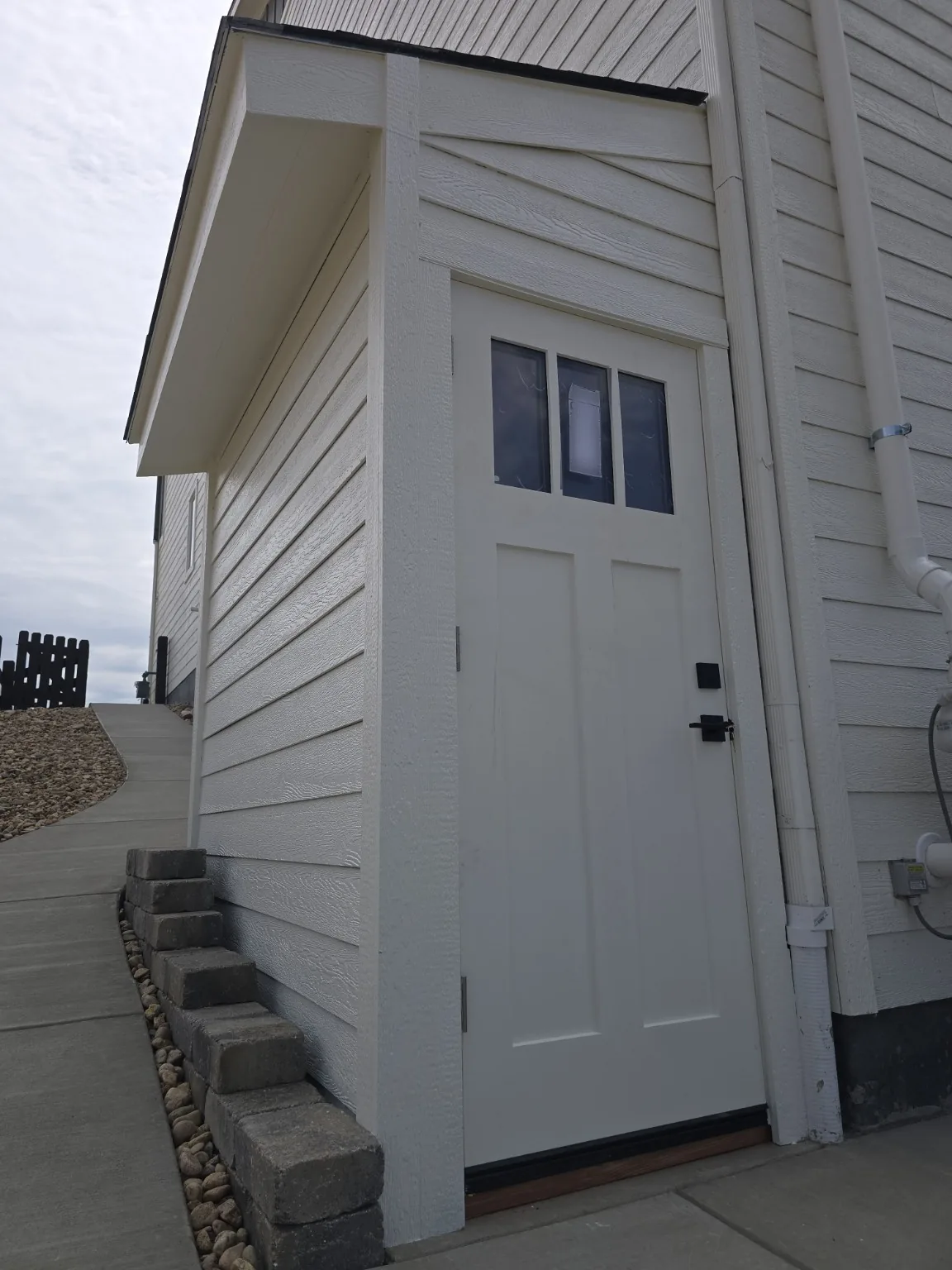Front elevation of the completed Castle Rock basement entrance enclosure with matched siding and trim