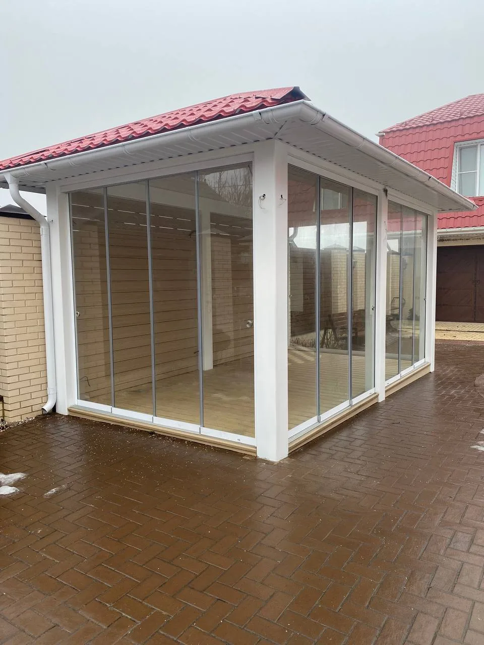 White-framed patio enclosure with full-height sliding glass walls